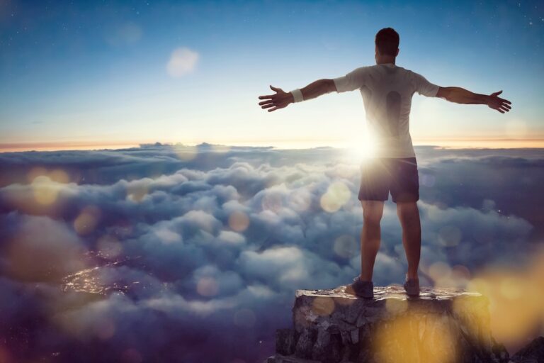 Mann über den Wolken breitet Arme aus